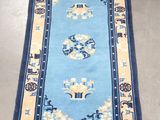 tapis oriental bleu et beige orné d'un motif oriental