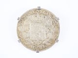 an old silver coin on a white surface with a crown on it