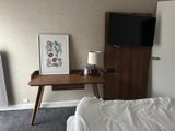a bed with a white comforter and a wooden desk
