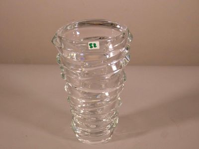 un vase en verre transparent sur lequel est collé un autocollant vert