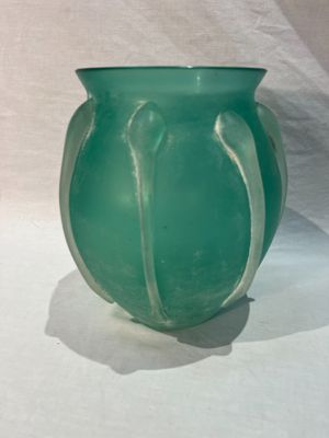 a green vase sitting on a table with a white background