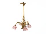 un lustre doré d'où pendent des fleurs roses