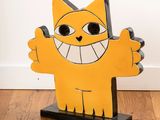 a yellow cat that is standing on a wooden stand