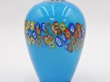 a blue vase with flowers painted on it on a white surface