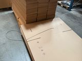 several stacks of cardboard are stacked on top of each other in a warehouse