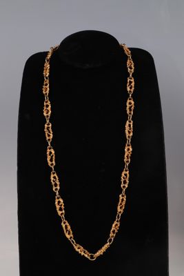 a gold chain necklace on a mannequin display