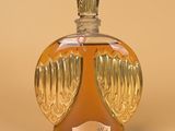 une bouteille en verre ornée d'ailes d'ange dorées
