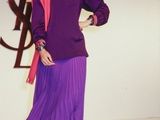 woman in purple dress and red shoes standing in front of a white backdrop