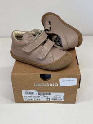 un gros plan d'une boîte sur laquelle est posée une paire de chaussures de bébé