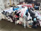 a large pile of clothes sitting on a pallet in a warehouse