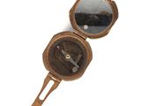une petite boussole en laiton sur laquelle est fixé un miroir