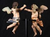two figurines of angels on a black stand