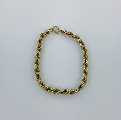 un bracelet en corde dorée sur fond blanc