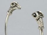 a close up of a silver bracelet with a dog head on it