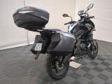 a black motorcycle parked in a garage with a helmet on the back of it