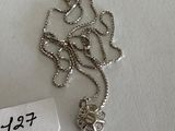 a silver necklace with a butterfly on it and a name tag