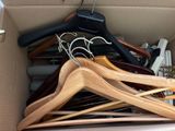 a cardboard box filled with clothes hangers and other clothes