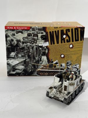 des jouets sont posés sur une table à côté d'une boîte sur laquelle figure l'image d'un véhicule militaire