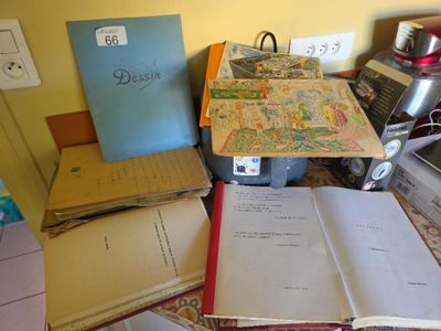 a pile of books on a table with a laptop on it
