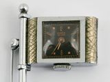a silver and gold watch with a pen on the side