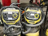 Plusieurs aspirateurs sont alignés les uns à côté des autres dans un garage