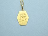 a gold plated necklace with a small hexagon pendant on a chain