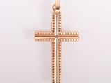 pendentif en forme de croix en or sur fond blanc