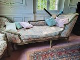 a couch with pillows and a guitar on it in a room