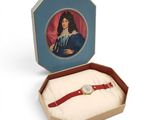 une photo représentant une femme en robe bleue et une montre rouge dans une boîte