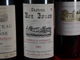 three bottles of wine sitting on a red table