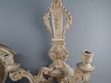 a candle holder that is on the wall next to a clock
