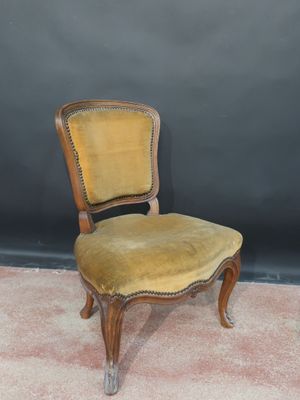 an old wooden chair with a yellow upholstered seat