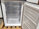 a small white refrigerator with its door open on a pallet