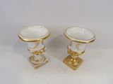pair of gold and white porcelain vases on stands on a white surface