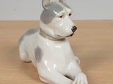 a white and gray dog figurine sitting on a table