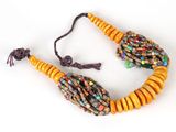 a close up of a necklace with beads on a white surface