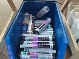 un bac bleu rempli de pots de peinture et de colle