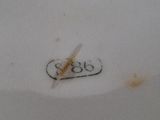 a white porcelain plate with a brown handle on it