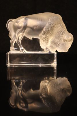 translucent glass figurine of a buffalo on a black surface