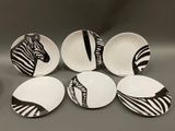 six plates with zebra designs on them sitting on a table