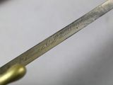 a close up of a person holding a knife with writing on it