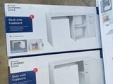 two boxes of white cupboards sitting on top of a floor