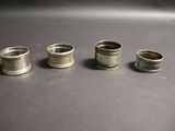 quatre bagues en argent de tailles différentes posées sur une table