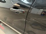 a close up of a car door handle with a hole in it