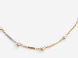 un collier en or orné de perles sur fond blanc