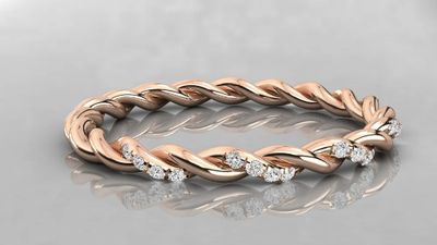 a rose gold braid ring with diamonds on a reflective surface
