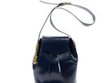 le petit sac seau en cuir bleu marine avec des finitions dorées
