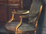 painting of a chair in a room with a painting on the wall