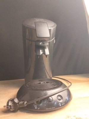 une cafetière posée sur une table en bois près d'une fenêtre
