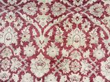 a close up of a red and white rug on a wooden floor